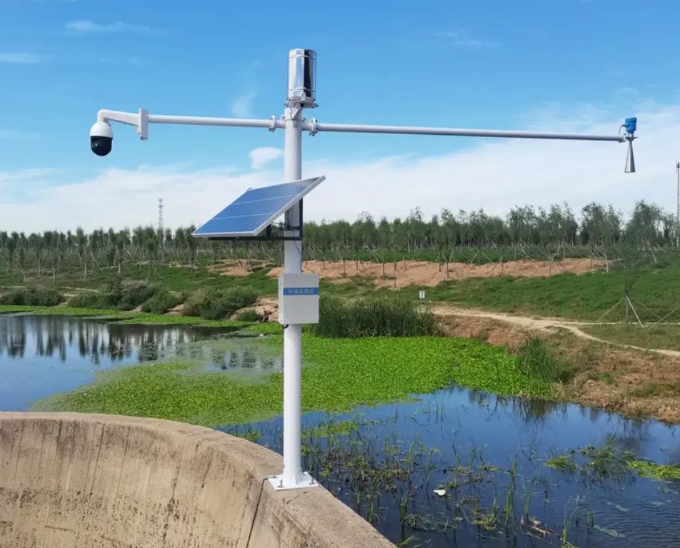 Side by side comparison of a solid-state 24GHz radar precipitation sensor and a traditional mechanical tipping bucket rain gauge in an agricultural research field.