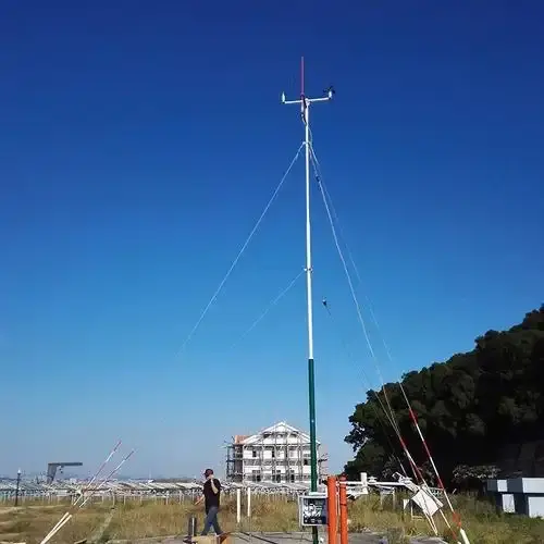 WMO standard 10-meter meteorological monitoring tower installed in an open landscape.